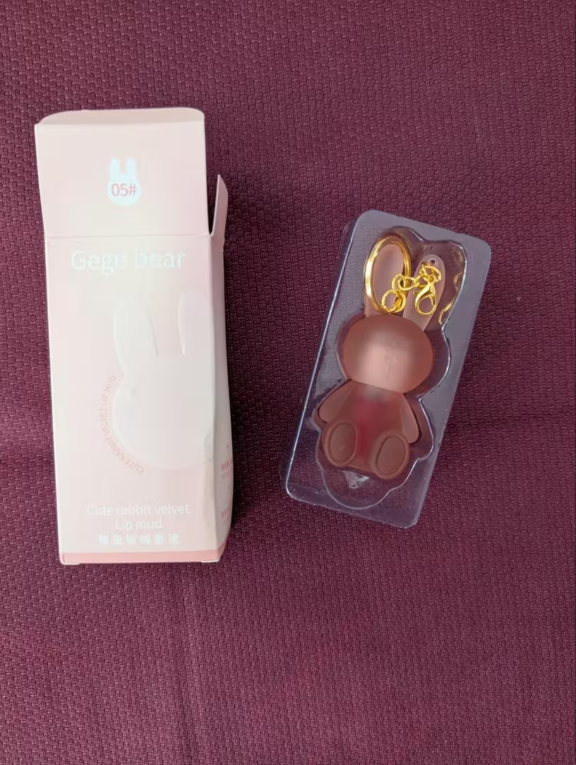 Bunny lip gloss in packaging tray next to pink box shade 03