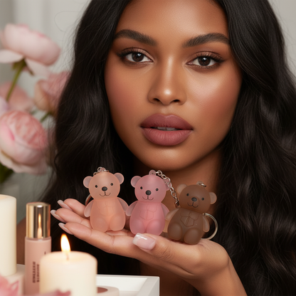 Woman with warm brown skin holding three Little Bear lip glaze shades